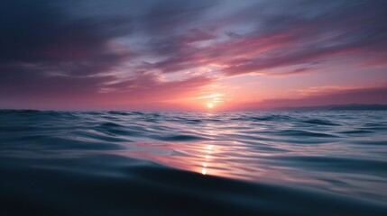 Obraz premium Beautiful landscape photograph of a sunset over the ocean. the sky is filled with vibrant colors of pink, orange, and purple, with the sun setting in the background.