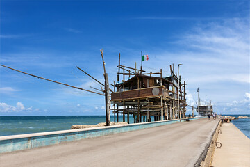 A trabocco structure stands on stilts over the water, representing traditional fishing methods. Traditional fishing house on Coast Of the Trabocchi. San Vito Chietino, Province of Chieti, Italy © Sergey