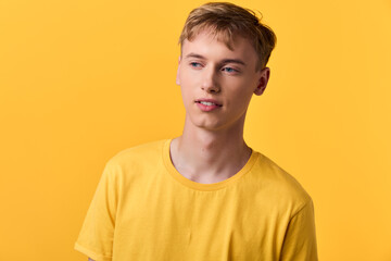 Fototapeta premium Young man in a yellow shirt against a vibrant yellow studio backdrop, casual fashion mood, clean lighting and minimal composition with warm color harmony