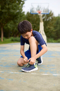 Boy lacing his basketball sneakers