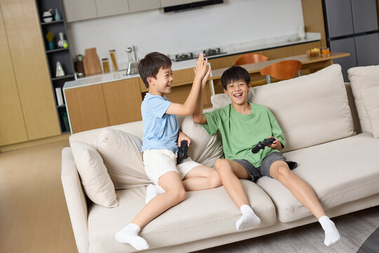 Happy boys playing video game on their smartphones