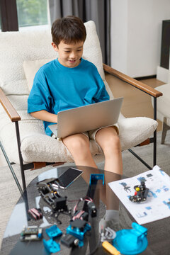 A boy focuses on assembling his new toy robot