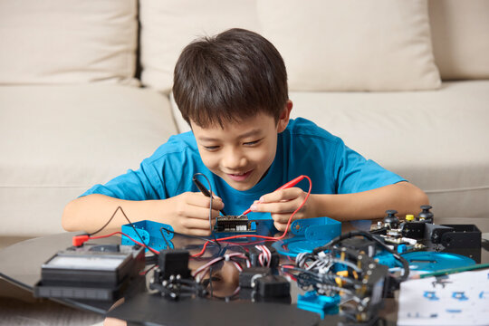 A boy focuses on assembling his new toy robot
