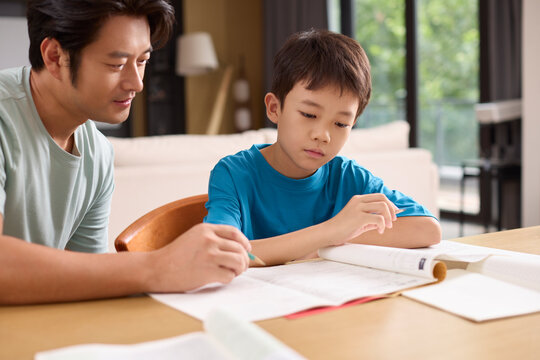 A father helps his son with homework