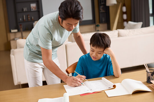 A father helps his son with homework