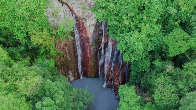Aerial view of tropical waterfall in jungle. Top down view with descending