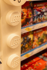 Fototapeta premium Chemnitz, Germany - March 14, 2026: A retail space shows LEGO blocks and sets arranged neatly on shelves. The branding and packaging highlight different LEGO themes.