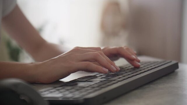 Hands typing on keyboard at desk
