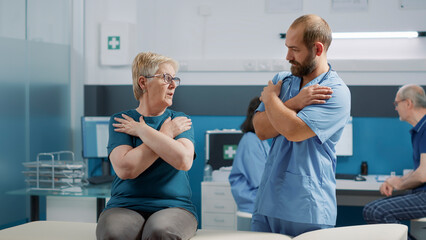 Orthopedic specialist practicing bones cracking on senior patient at physical therapy checkup. Male...