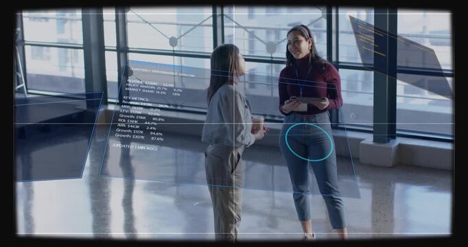 Holo analytics sliding in, two women in gray jacket reviewing tablet with lanyard in office atrium