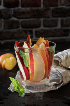 Glass of detox water with sliced red apple and mint