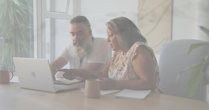 Mature man pointing at laptop and bringing finance chart while woman tapping phone checking papers