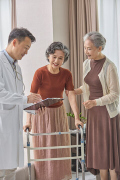 Senior woman using a walking frame under her doctor's supervision