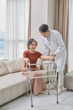 Senior woman using a walking frame under her doctor's supervision
