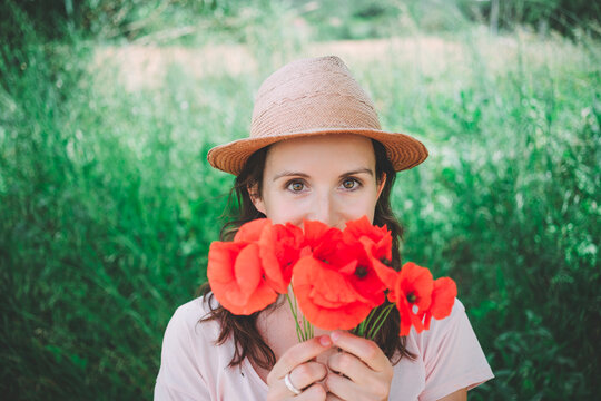 Woman holding a bouquet of red poppies in spring