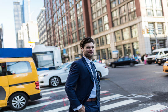 Businessman in the streets of Manhattan with yellow cab in background