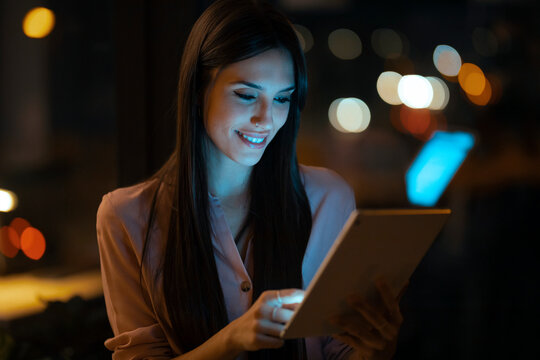 Portrait of smiling young woman using digital tablet in office