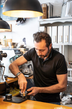 Barista preparing portafilter of coffee machine in a coffee shop