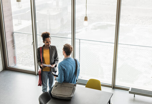 Young business people discussing files in office