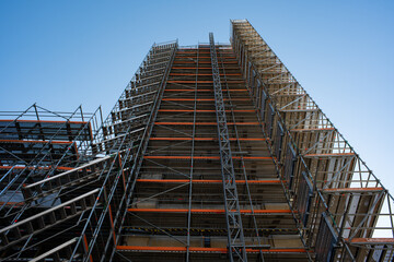 Naklejka premium Scaffolding on a tall building under a clear blue sky