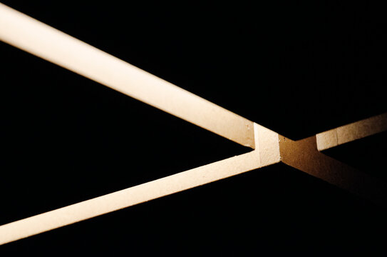 Minimalist Geometric Intersect: Light and Shadow Abstract. Conceptual Architectural Composition with Warm Tonal Contrast and High-End Negative Space Background.
