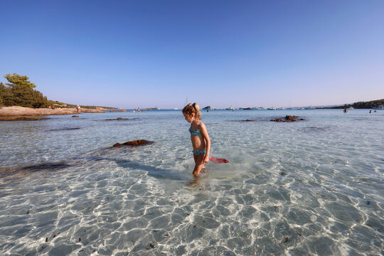 Bimba con retino in mare sulla spiaggia di Cala Brandinchi, San Teodoro, Olbia, Sardegna, Italia, Europa