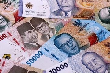 Indonesian rupiah money bills pile on table. Indonesia banknotes of IDR currency close up. © Larysa