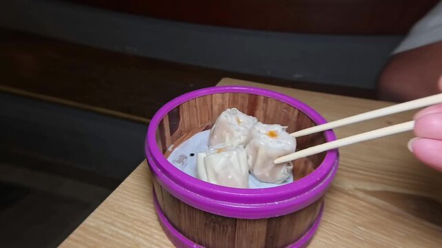 Taking Steamed Dim Sum With Wooden Chopsticks