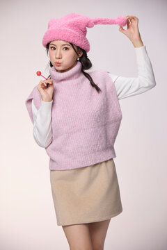 A beautiful young woman holds a lollipop