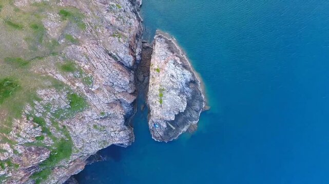 Aerial top down drone view of rugged rock formations meeting clear blue ocean water at Hon Chong Hon Vo coastal landmark in Nha Trang Khanh Hoa Province Vietnam