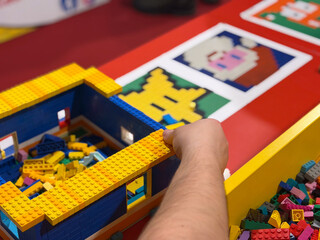 Naklejka premium Child building colorful toy brick structure on table