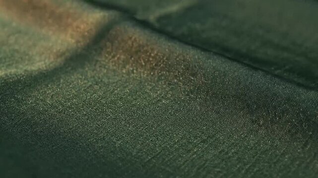 Dark green shimmering fabric texture with elegant folds