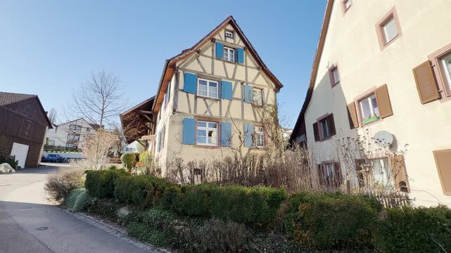 Old half-timbered houses in L&ouml;rrach, Germany, one with blue shutters, panning shot