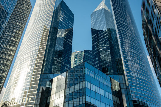 Modern architecture frames glass skyscraper perspective in Paris La Defense financial district with urban skyline lines rising toward the sky