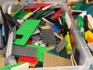 Naklejka premium Colorful building brick plates in storage bin