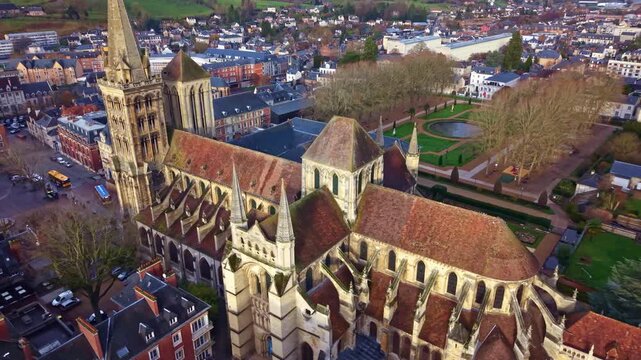 Drone aerial orbit of Saint Peter Cathedral, historic gothic church surrounded by the town center buildings and public gardens.
