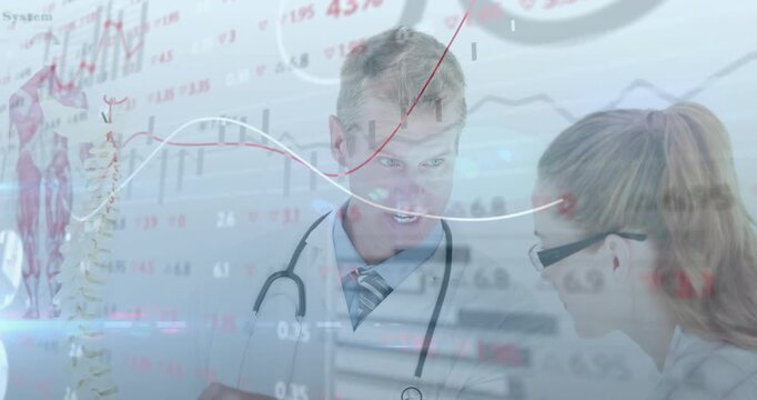 Moving graphs revealing medical doctor pointing at spine while peer reading chart reviewing data