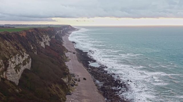 Drone flying along the coastline, cliffs, on the Alabaster coast, Saint-Jouin-Bruneval beach in Normandy in France. Aerial drone forward