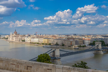 Fototapeta premium BUDAPEST, HUNGARY, JULY 21, 2024 - Overview of the city of Budaspet on the river Danube with Chain Bridge and the Hungarian Parliament Building in Budapest, Hungary