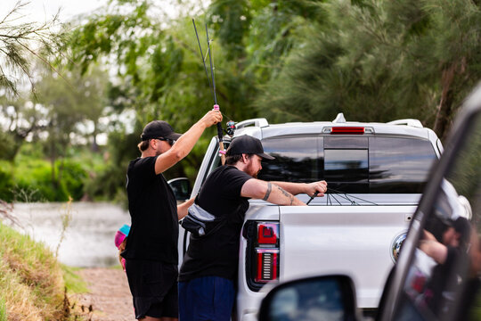 Fishermen getting ready to go home after fishing loading ute by riverside