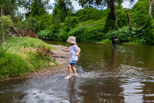 Child splashing through water at summertime in river