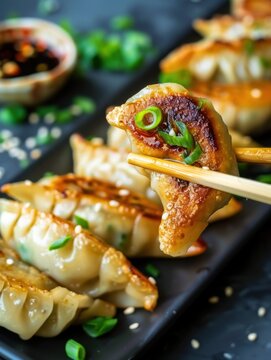 Delicious gedza with cabbage and pork served on a black plate with chopsticks in an inviting dining setting