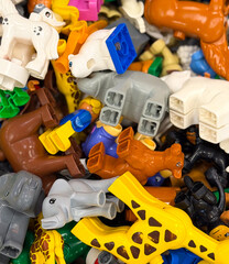 Naklejka premium Colorful pile of plastic toy animal parts flat lay close-up