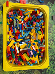 Naklejka premium Colorful building bricks in yellow tray