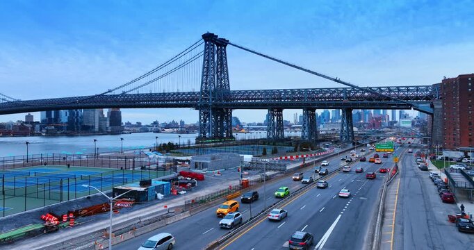 Numerous cars move by the FDR Drive along the East Side River Park being developed. Low angle view at the Williamsburg Bridge in New York, USA.