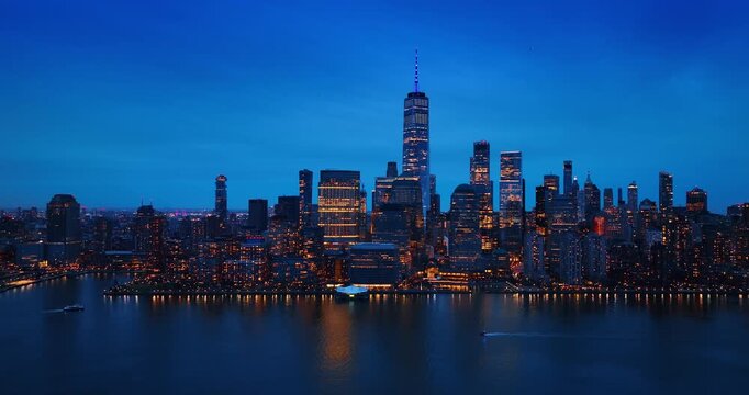 Ski jet and motor boat moves by the peaceful waterscape of the East River. Gorgeous skyline of New York, USA at sunset from the riverscape.