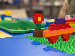 Naklejka premium Colorful lego flower and vehicle on green baseplate