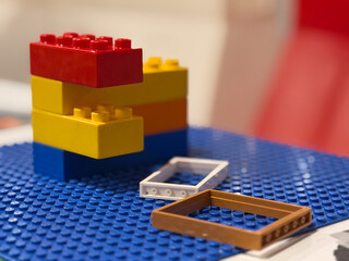 Naklejka premium Colorful plastic building blocks on blue baseplate