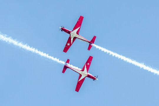 Aerial view of two red and white aircraft soaring the sky sky, leaving trails of white smoke, Changi Exhibition Centre, Singapore Air Show 2026, Singapore.