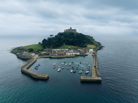 Aerial view of St Michael's Mount rises majestically out of the sea, a stark contrast to the calm harbor waters, Marazion, England, United Kingdom.